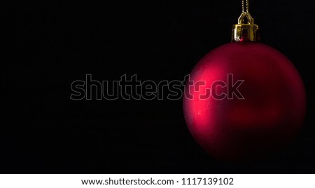 Red christmas balls on wooden board agaisnt dark background