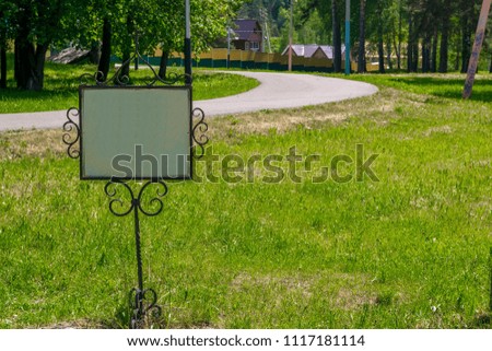 sign on a metal frame on the lawn near the road in the countryside, in the Park