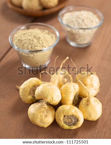 Fresh maca roots or Peruvian ginseng (lat. Lepidium meyenii) with maca products (maca powder, oatmeal with maca, maca cookies) in the back (Selective Focus, Focus on the maca roots in the front) Royalty-Free Stock Photo #111725501