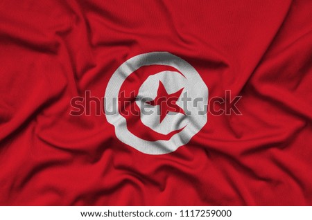 Tunisia flag  is depicted on a sports cloth fabric with many folds. Sport team banner