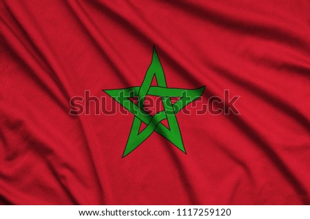 Morocco flag  is depicted on a sports cloth fabric with many folds. Sport team banner Royalty-Free Stock Photo #1117259120