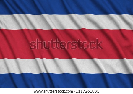 Costa Rica flag  is depicted on a sports cloth fabric with many folds. Sport team banner