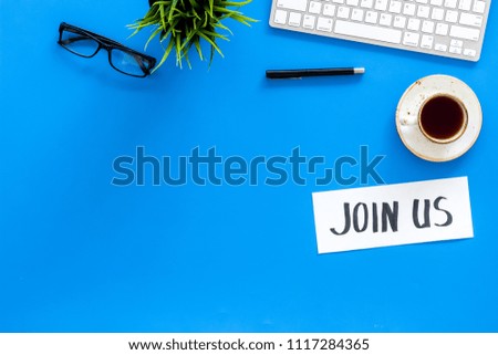 Template for socail media links. Hand lettering Join us on work desk with glasses, coffe, plant, computer keyboard on blue background top view copy space