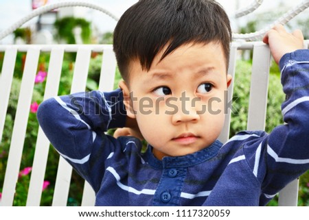 Handsome boy portrait sitting on the white swing for relaxing on long holiday - Relaxing of concept