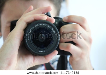Young caucasian man taking selfie picture in a mirror with dslr professional camera