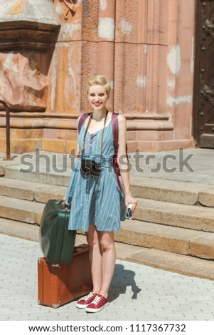 beautiful tourist with camera and vintage travel bags