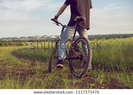 Young cyclist. Cross-country riding, cycling, activity and sports. Man riding a bicycle at countryside . Environmentally friendly transport, clean air, activity, healthy lifestyle concept