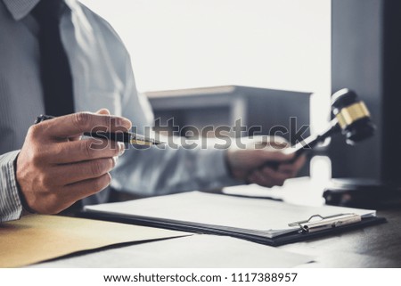 Judge gavel with Justice lawyers, Businessman in suit or lawyer working on a documents in courtroom. Legal law, advice and justice concept.