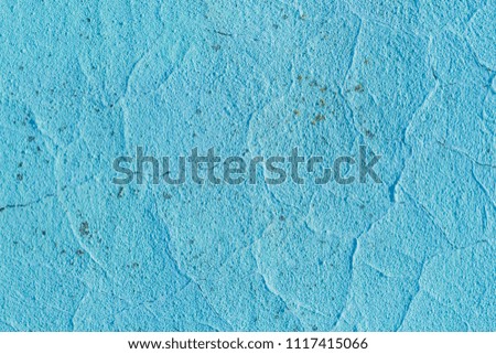 Texture of a concrete wall. Cracks and irregularities on light blue plaster. Abstract background.