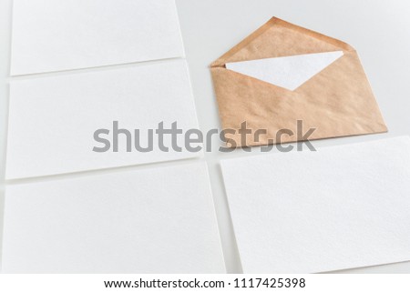 Mockup of horizontal business cards in rows and brown craft envelope at white background.