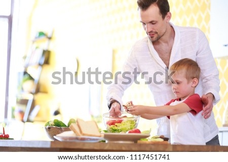 Image of man and son preparing salad