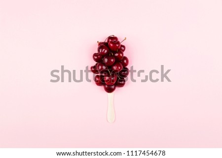Ripe cherry in form of ice cream popsicles on a pink background. Top view. Food background