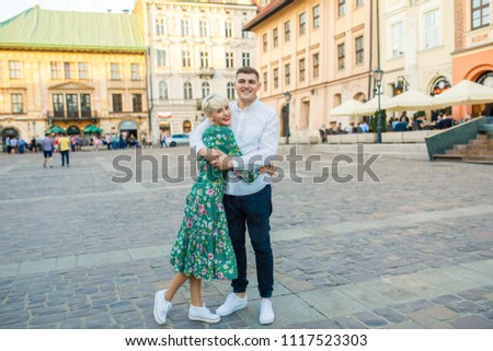 young beautiful couple of tourists stand in the square in the city of Krakow in Poland
