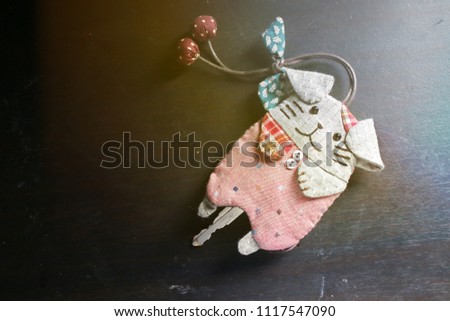 Handmade felt keychain for bag charm on Wooden background.