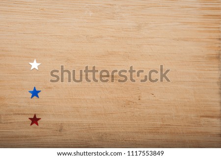 Confetti stars on wooden background check marks. 4th July, Independence day, card, invitation in usa flag colors. Top view, empty space.
