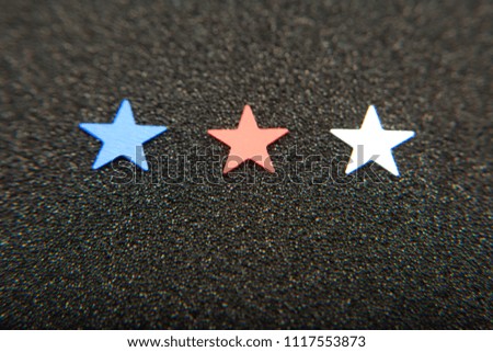 Confetti stars on black background. 4th July, Independence day, card, invitation in usa flag colors. Top view, empty space.