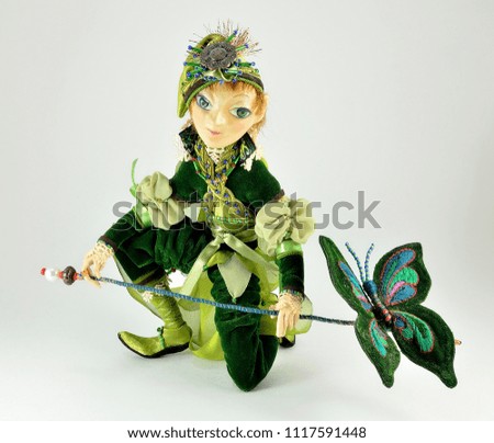 Decorative doll in a green caftan on a white background