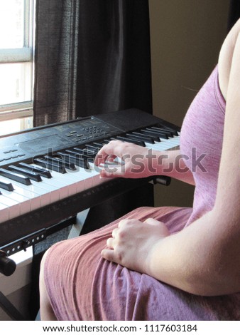 Woman practicing playing the keyboard piano 