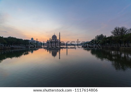Beautiful sunrise scenery of a mosque by a lake with reflection at Putrajaya, Malaysia
