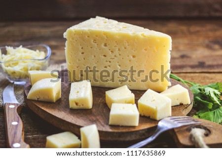 sliced cheese on a wooden board Royalty-Free Stock Photo #1117635869