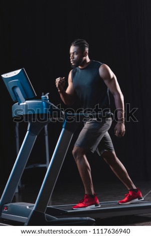 handsome young african american sportsman running on treadmill