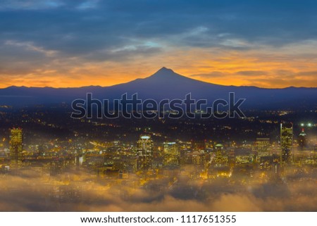 Foggy morning at Portland Oregon downtown city skyline with Mount Hood silhouette at dawn