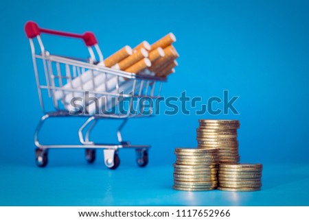 Cost of smoking concept. Cigarettes shopping cart money gold coins