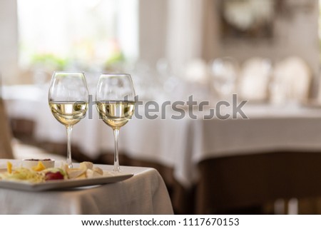 Photo of bottle with pouring champagne in wine glasses on gray background