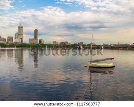 A sailboat on a river against the Boston skyline
