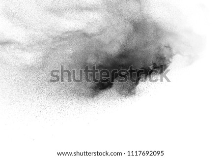 Black powder explosion on white background. Abstract black dust particles splash on white background.