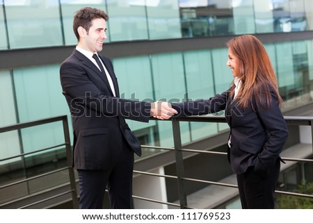 Businesspeople shaking hands at modern office