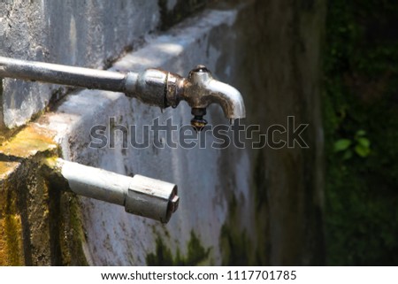 Image of a water tap with water drop
