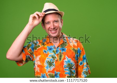 Mature tourist man ready for vacation against green background