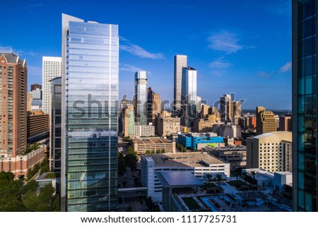 New silver modern tower rising up into the blue sky in Houston Texas skyline cityscape modern urban skyscrapers rising up along gulf coast Texas city aerial drone view of amazing city downtown view