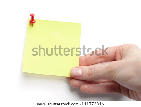 Hand with yellow sticky note on white background