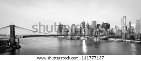 New York City skyline with  Brooklyn Bridge and  Lower Manhattan view in early morning sun light - Black and white Royalty-Free Stock Photo #111777137