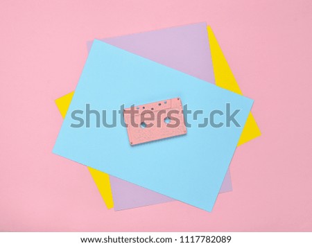 Audio cassette on a pastel-colored paper background. Retro media technology 80s. Music, entertainment. Top view. minimalism trend
