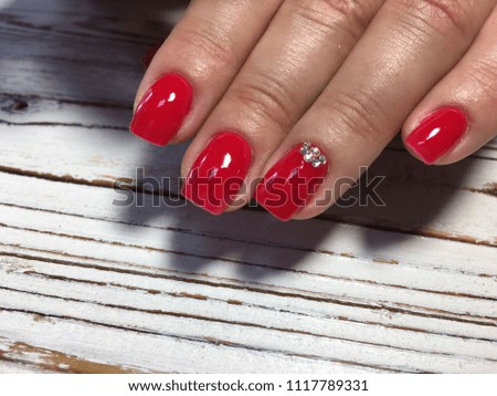 fashionable red manicure with a gold design on a gray textured background