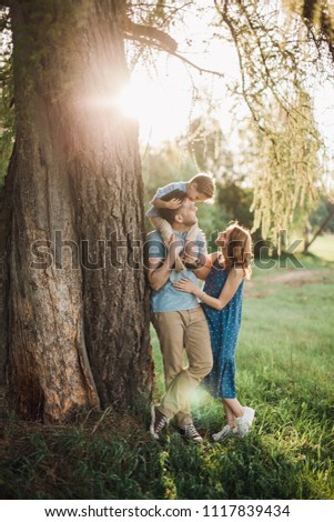 beautiful family on nature countryside father mother son sunset