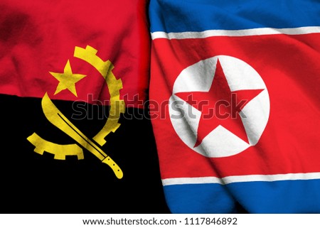 Angola and North Korea flag on cloth texture