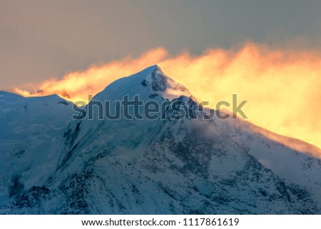 Backlit image at the sunrise on Mont Blanc - the highest mountain peak in Europe. In the first plan you can see L'aiguille de Bionnassay.