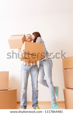 Image of couple in love among cardboard boxes in new apartment