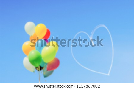 Defocused background, colorful balloons and heart written in the sky. Intentionally blurred post production for bokeh effect