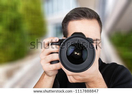 Soft focus of photographer hold camera and taking a photo.