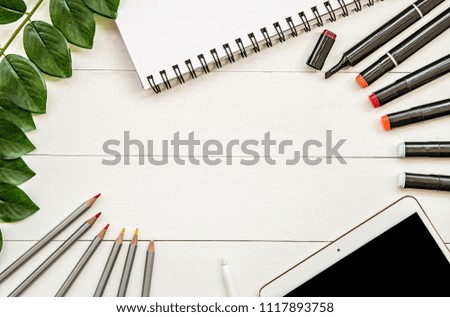 designer or illustrator working place. drawing and sketching pencils,markers, sketchbook and fake plant flat lay top view on white wooden background with copy space