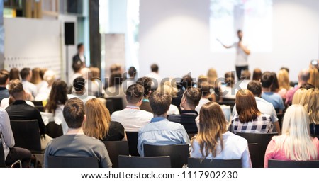 Speaker giving a talk in conference hall at business event. Audience at the conference hall. Business and Entrepreneurship concept. Focus on unrecognizable people in audience. Royalty-Free Stock Photo #1117902230