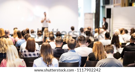 Speaker giving a talk in conference hall at business event. Audience at the conference hall. Business and Entrepreneurship concept. Focus on unrecognizable people in audience. Royalty-Free Stock Photo #1117902242