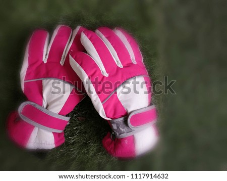 Golf glove in pink and white​ color on green. Blurred​ and copy space