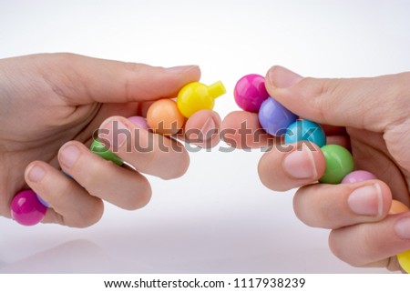 Hand holding Color beads with facial expression on white background