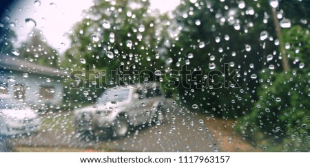 Blur bokeh raindrops view inside the car on the glass mirror